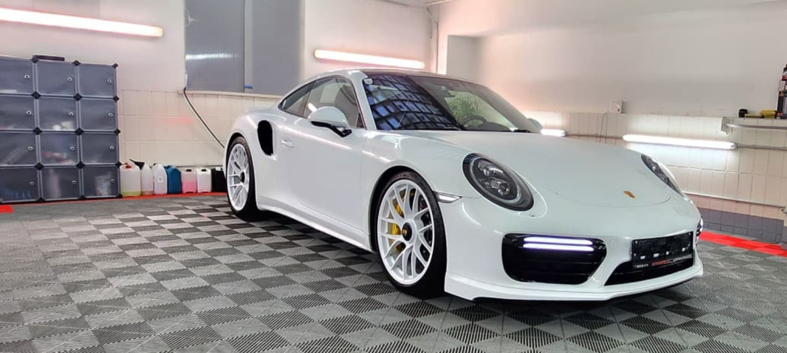 Weißer Porsche 911 Turbo in Aufbereitungshalle